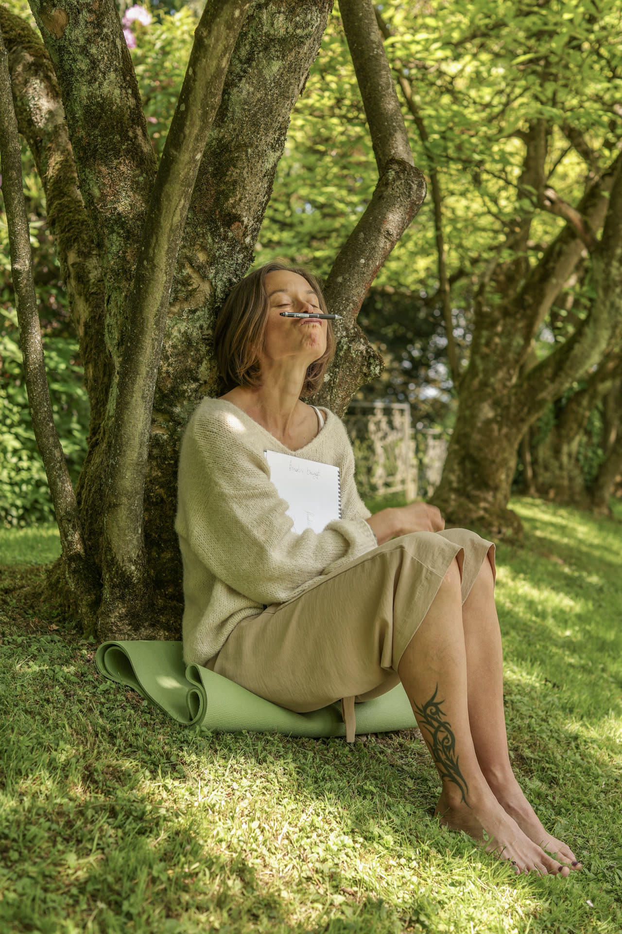 Sabina sitzt entspannt und meditativ im Gras